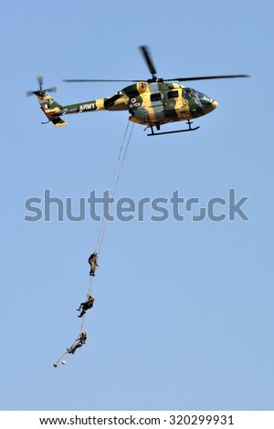 BENGALURU, INDIA - FEBRUARY 22, 2015: Indian Army\'s HAL ALH Dhruv performing Special Patrol Insertion/Extraction (SPIE) of its personnel during Aero India 2015.