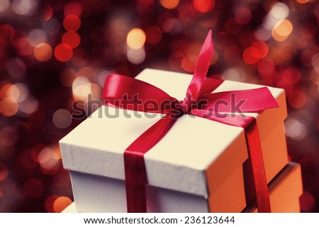 Close up of gift box with red bow on abstract background