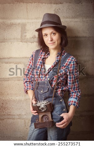 Indoor portrait of woman in a hipster style with vintage camera