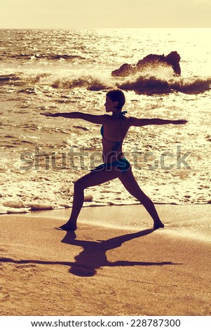 A vintage yoga warrior position on a beach