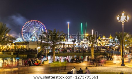Main square and lake in Global Village with crowd and attractions  in Dubai, UAE. Brightly colouredl lights and highly detailed pavilion facades have helped make Global Village one of Dubai's mos Stock fotó © 