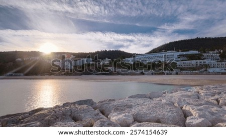 Similar – Image, Stock Photo Behind the hill with plants, a bright glow appears against the already darkened sky. The sun sets on the horizon.