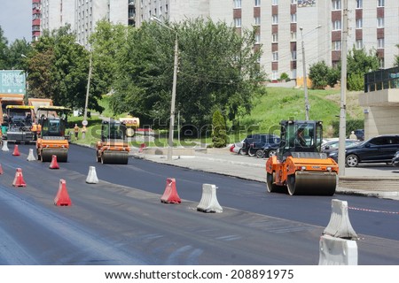 Kharkiv - JULY, 27 2014: team of builders puts asphalt on the street according to the city plan Klochkivska overhaul of the roads in 2014