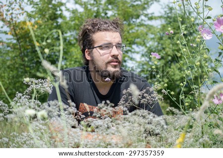 the guy with the beard among the flowers in the meadow