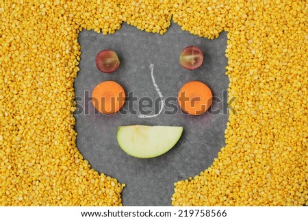 Happy fruit, bean and vegetables face on black background.