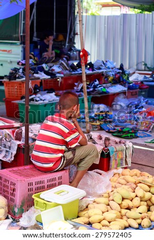 Nongkhai, Thailand - May 016: Unidentified  boy is shop seller at fruit shop wait his customer buy his goods at Thai-Laos vintage market on Phonphisia in Nongkhai, Thailand on May 16, 2015.