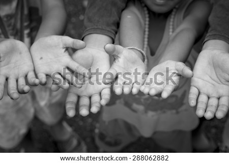 Children Raising hands beg for some food.Filtered gray tone.