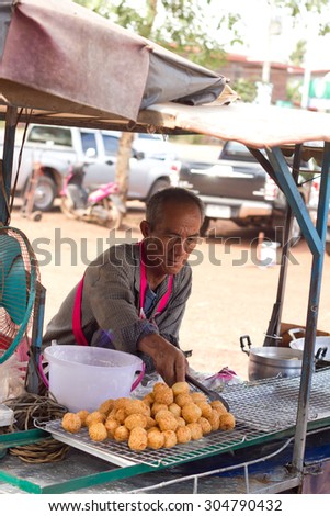 Nongkhai, Thailand - May 18: Unidentified  smiling shop seller of Thai\'s dessert selling his goods to his customer at Thai-Laos vintage market on Phonphisia in Nongkhai, Thailand on May 18, 2015.