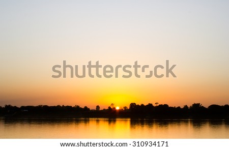 Gold light on sun set with light on the river.Idyllic Wallpaper Setting Sun.