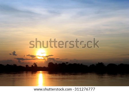 Gold light on sun set with light on the river.Idyllic Wallpaper Setting Sun.