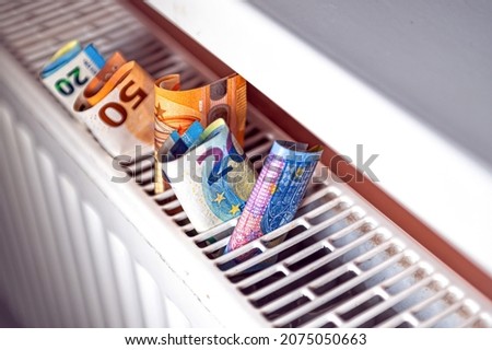 euro banknotes in a central heating radiator, the concept of expensive heating costs, close-up 商業照片 © 