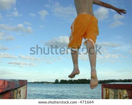Child jumping off dock into water