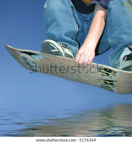 youth jumping over water on skateboard deck
