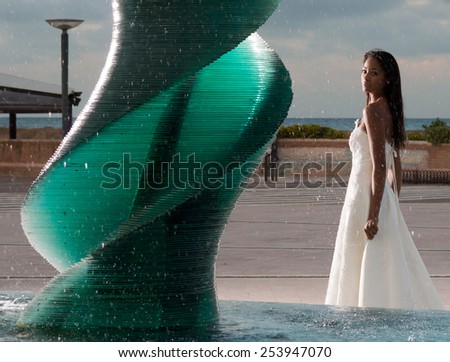 Brazilian model posing dressed like a bride near a fountain in Riccione