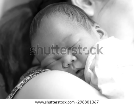 Asian  Thai  girl baby sleep on mother \'s shoulder closeup black and white
