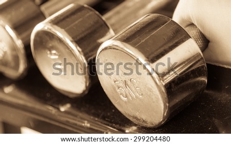 Asian male  hand grab dumbell copper black and white closeup