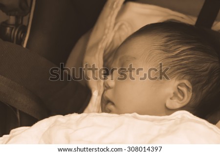 Asian Thai baby sleeping on stroller with sepia tone golden vintage