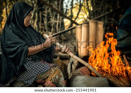 Old woman are cooking sugar fresh from water of jaggery tree