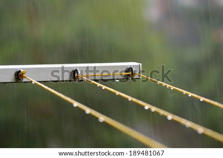 Rain, cloudy rainy day and wet clothesline with raindrops.