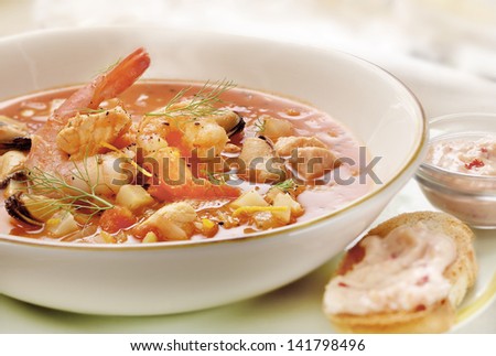 fish soup served on a plate with prawns and mussel