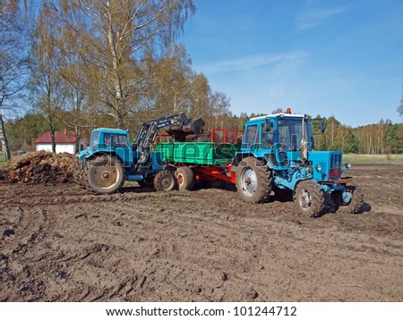 Loading manure spreader by tractor front loader
