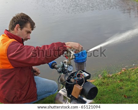 Electrician repairing the water pump near pond