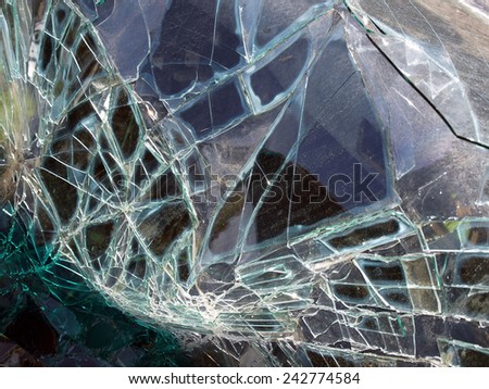 Broken car windscreen with glass pieces and crashes close up