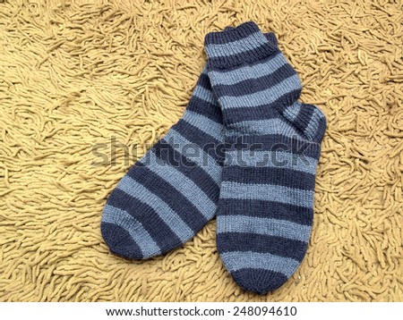 Dark and bright blue striped socks on soft carpet together