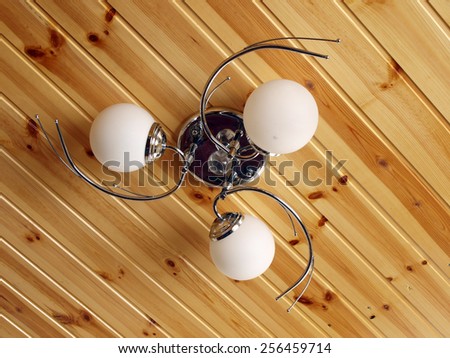 Pendant lamp with three bulbs on wooden ceiling