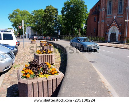 LIEPAJA, LATVIA - JUNE 28, 2015: Cubic decorative concrete flower boxes are placed near parking place border.
