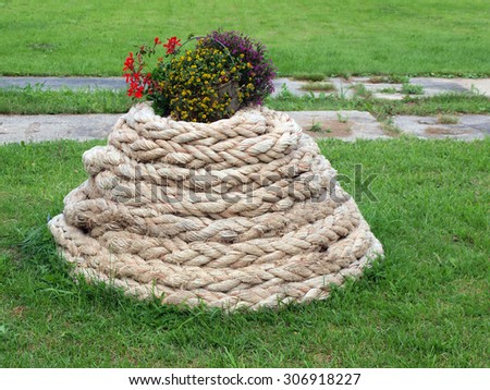 Homemade garden decor from flower pot and old rope.