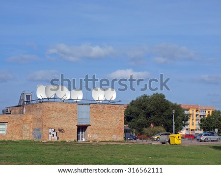 LIEPAJA, LATVIA - SEPTEMBER 14, 2015: Cable television and internet provider station with satellite antennas on roof is located in small brick building on Ganibu street.