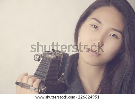 Beautiful young woman with a old camera