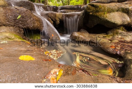 The fifth level of Erawan waterfall in Thailand, swirling of leaves in the pond