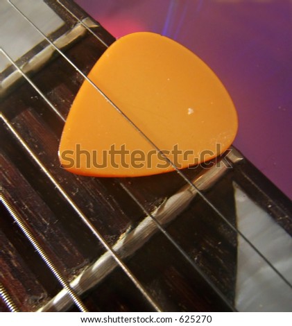 guitar pick between strings