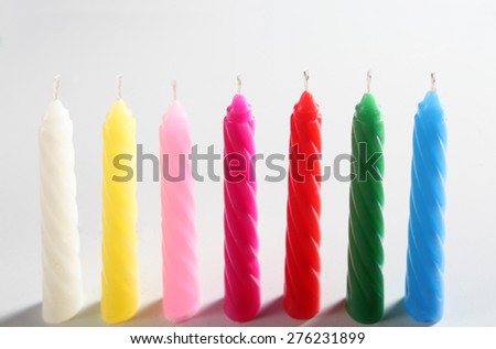 seven colored candles on white background