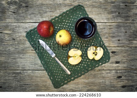 Beautiful still-life composition with juice in a glass, apples and fruit knife on old wooden background. Grunge style. Delicious fruit. Image of natural materials.