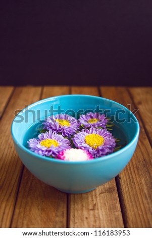 Cut flowers in bowl of water. Spa concept.