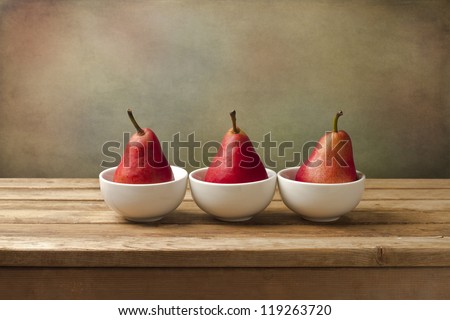 Fine art still life with red pears on wooden table
