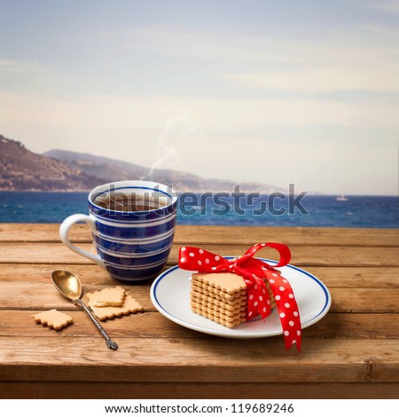 Cup of tea with cookies over beautiful view of the sea