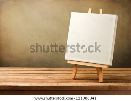 Background with blank canvas on wooden table over grunge background