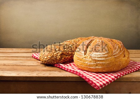 Fresh bread on tablecloth on wooden vintage table