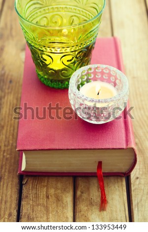 Decorative candles on book over wooden background