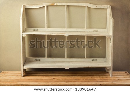 Vintage shelf on wooden table over grunge background. Can be used for product display.