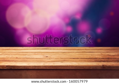 Christmas background with empty wooden table and purple bokeh