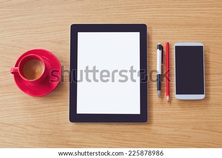 Tablet with blank screen on wooden table. Office desk mock up. View from above