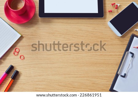 Modern office table background with table, smart phone, notepad and coffee cup. View from above with copy space
