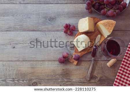 Wine, cheese and grapes on wooden table. View from above with copy space
