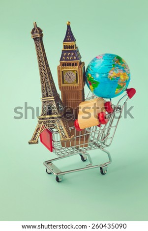 Travel around the world concept. Shopping cart with souvenir from around the world. Retro filter effect