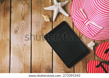 Summer holiday background with digital tablet on wooden table